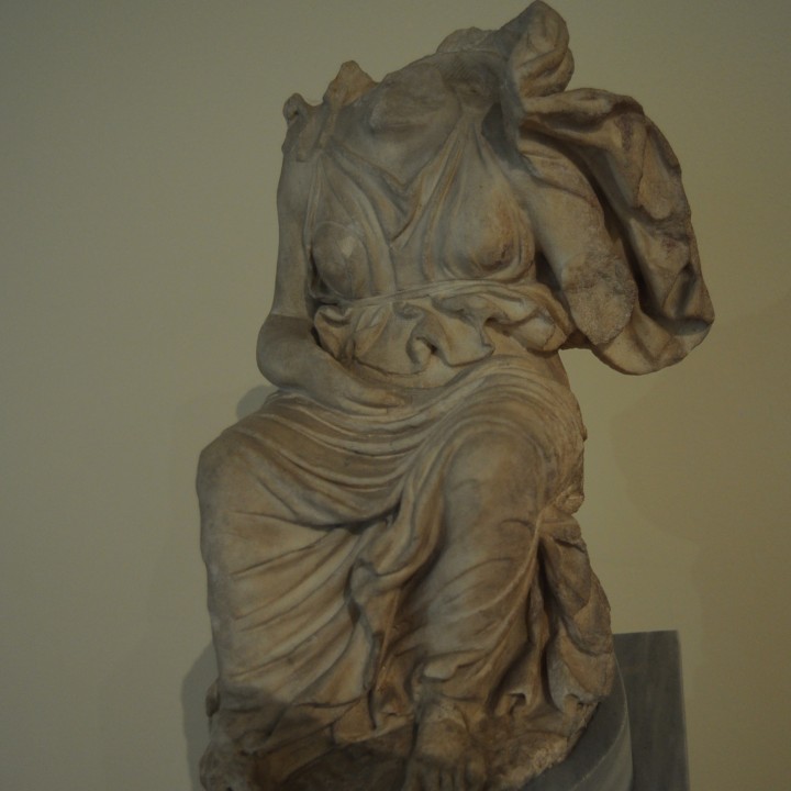 Statuette of a goddess seated on a rock image